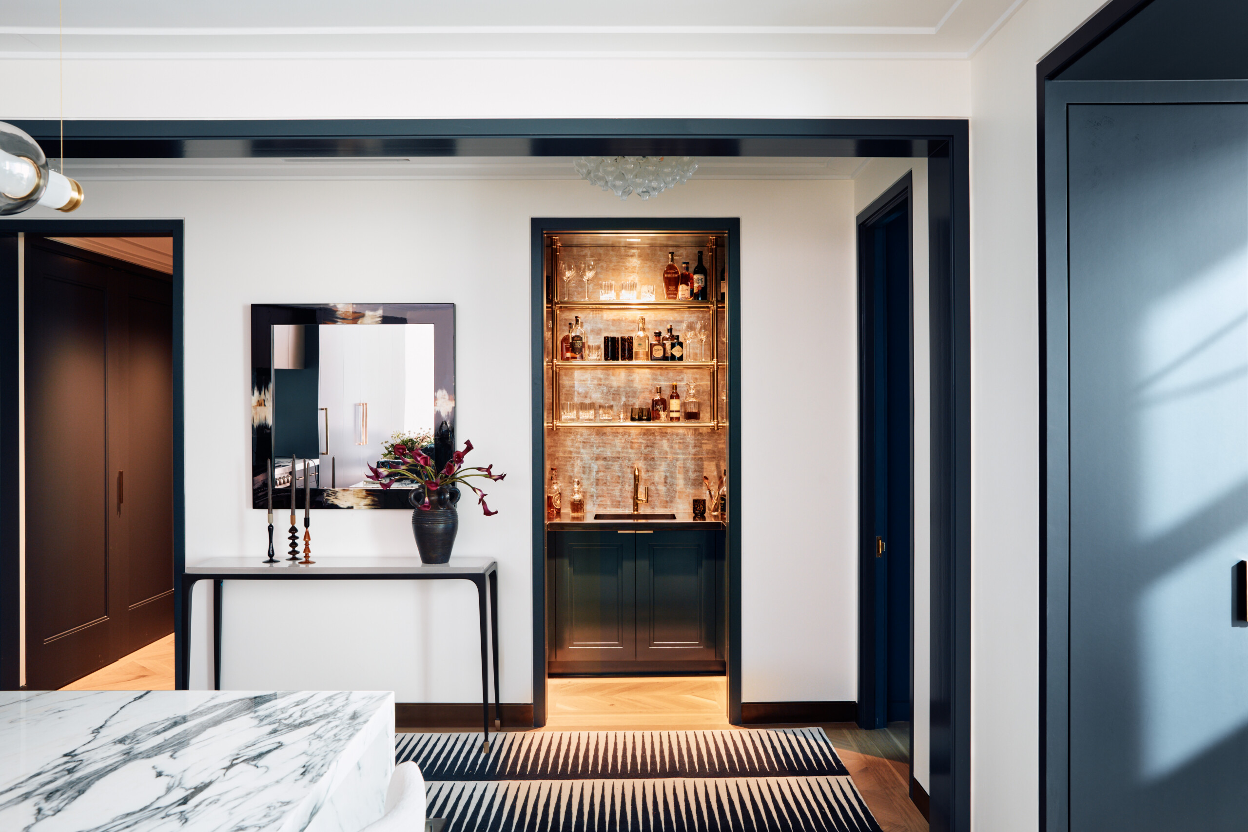 The Music Row Duplex foyer features a console table with a mirror and design objects and a peek-a-boo...